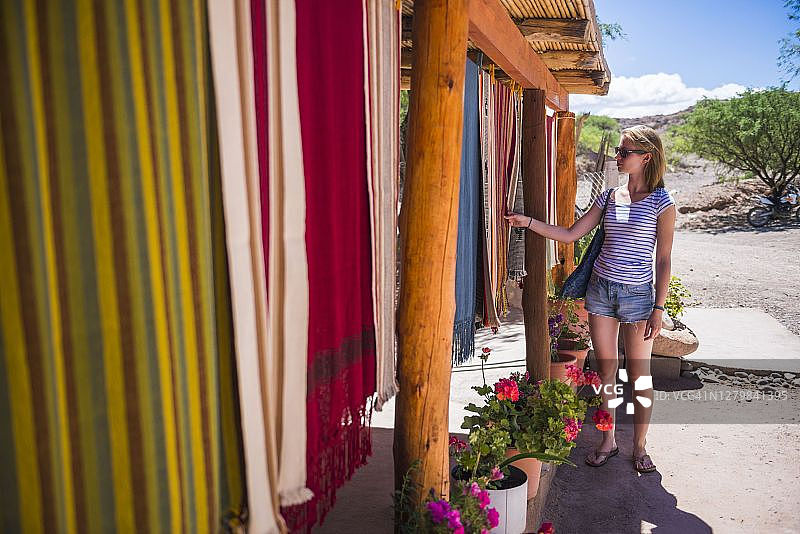 在阿根廷北部萨尔塔省卡奇山谷的工匠路上购物的女人图片素材