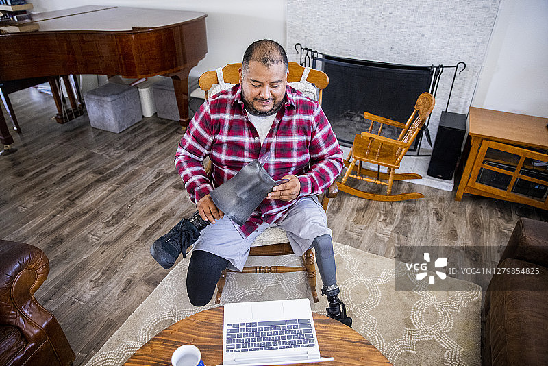 西班牙裔退伍截肢军人与医生进行远程医疗通话图片素材