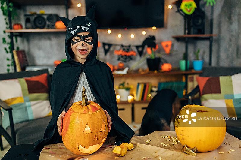 可爱的小男孩打扮成蝙蝠侠，万圣节期间玩得很开心图片素材