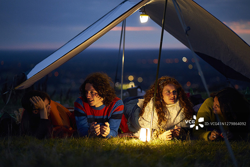日落时分，朋友们依偎在帐篷里聊天图片素材
