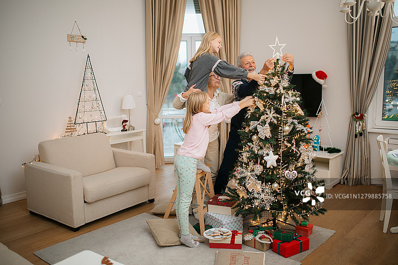 幸福的家庭用装饰品装饰圣诞树图片素材