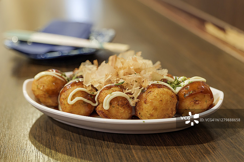 日式章鱼小丸子，在日式餐厅的木制柜台上图片素材