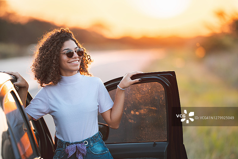 在车外欣赏日落的青少年图片素材