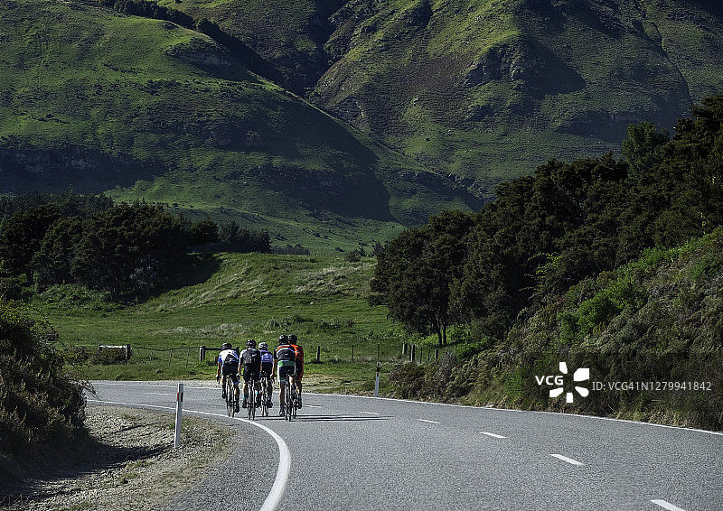 一群自行车手在新西兰南岛的道路上骑行图片素材