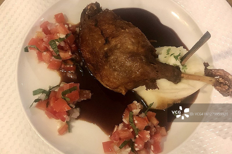 法式美食背景：油封鸭腿配棕色酱汁、新鲜番茄沙司和土豆泥图片素材