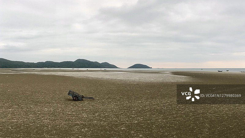 阴天早晨退潮时留在尖竹汶府昭老海滩上的木制独轮车图片素材