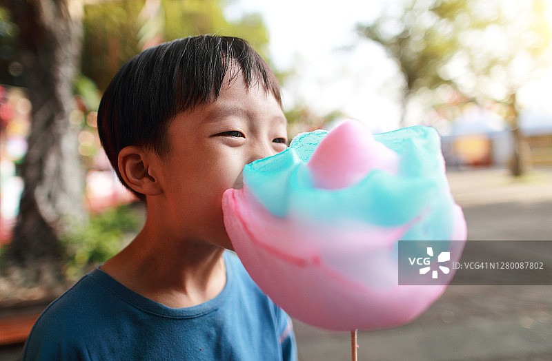 小男孩在游乐园吃棉花糖图片素材