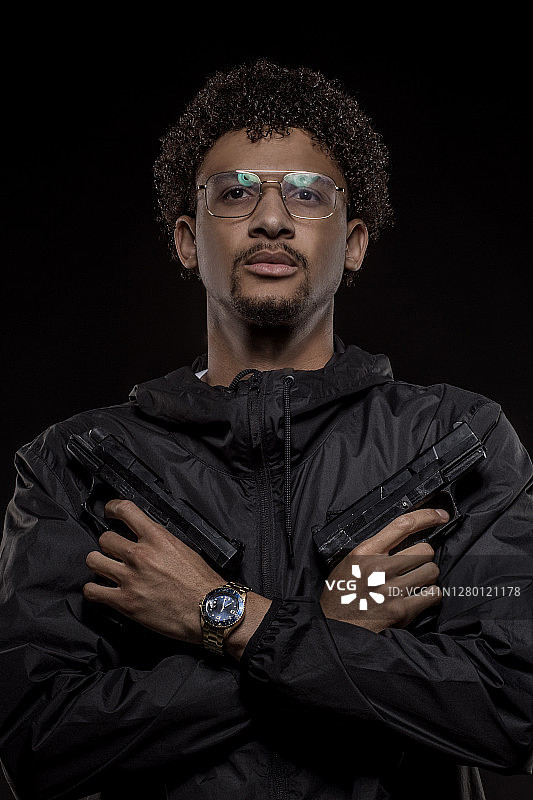 影棚里的持枪年轻黑人男性肖像图片素材