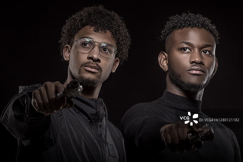 两名持械的年轻黑人男性在影棚拍摄图片素材