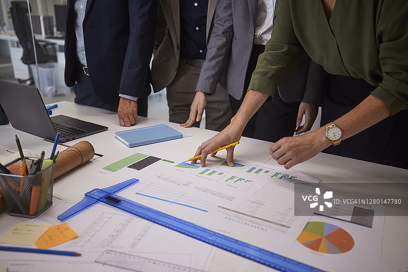 办公室里同事在桌子上讨论项目文件图片素材