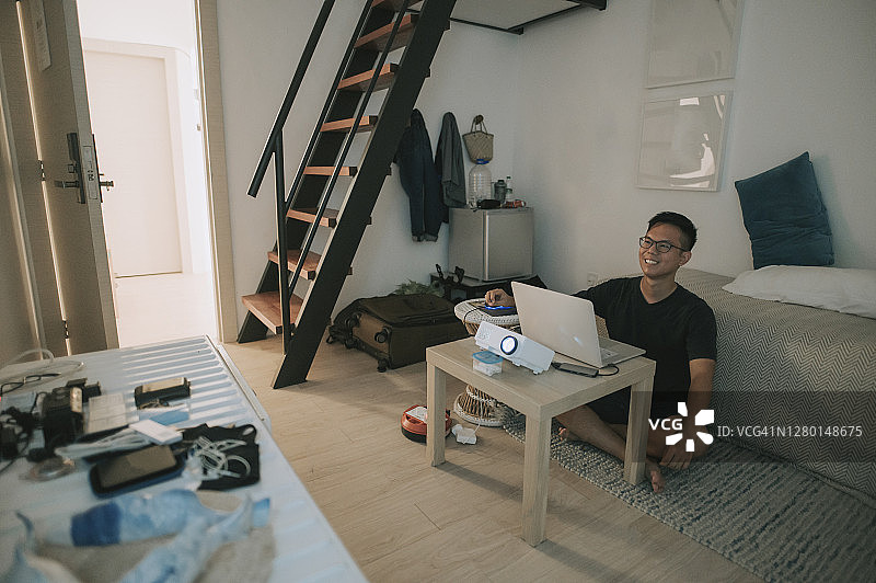 中国男性在家使用笔记本电脑和投影仪屏幕进行视频会议图片素材