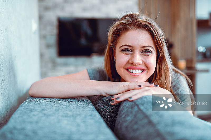 微笑的女人在客厅里的肖像图片素材