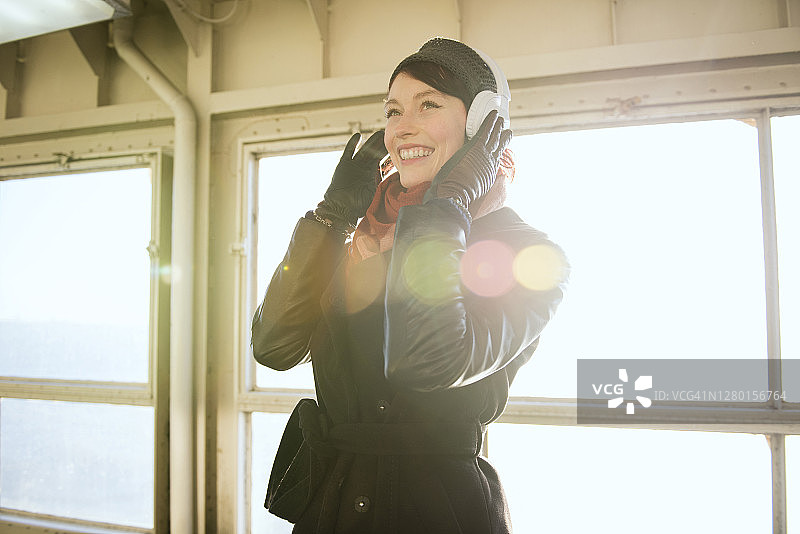 年轻女子戴着无线耳机听音乐图片素材