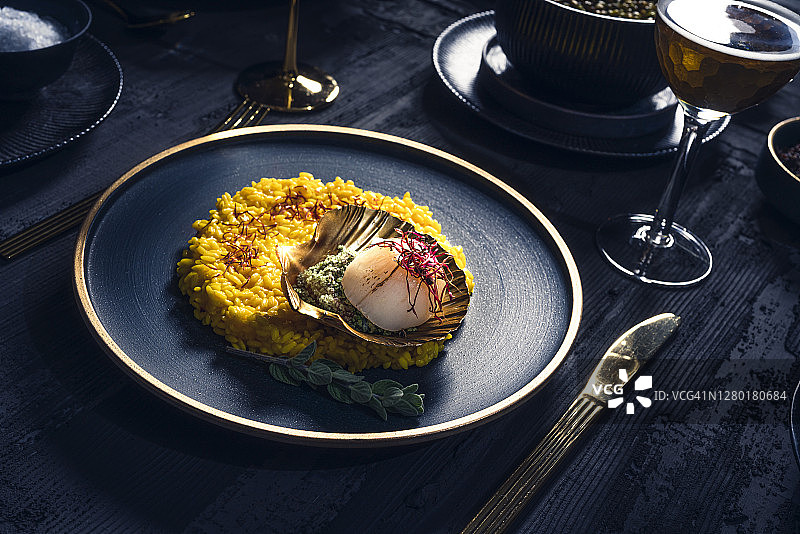 藏红花米饭扇贝搭配高档餐具和金色餐具图片素材