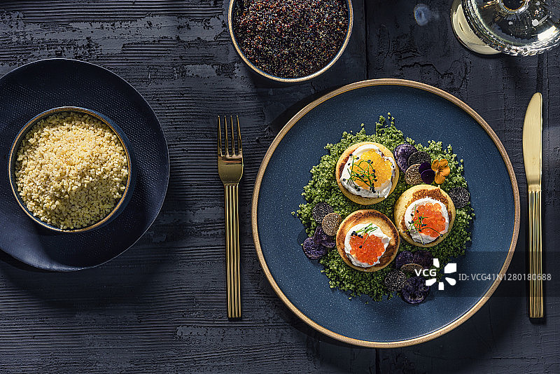 豪华鱼子酱菜单，搭配精致餐具和金色餐具，置于乡村背景之上图片素材