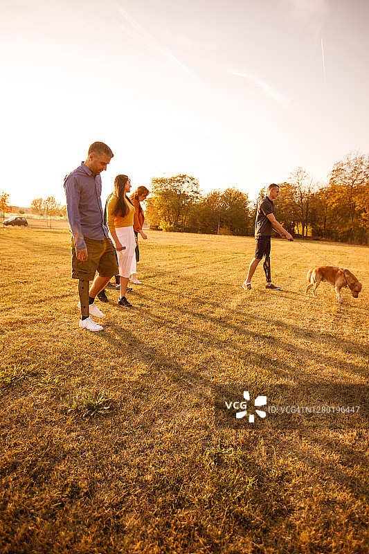 在公园里行走的装有假肢的人们的全身照图片素材