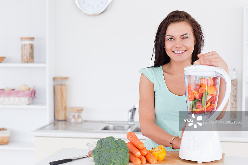 迷人的女人使用搅拌机图片素材