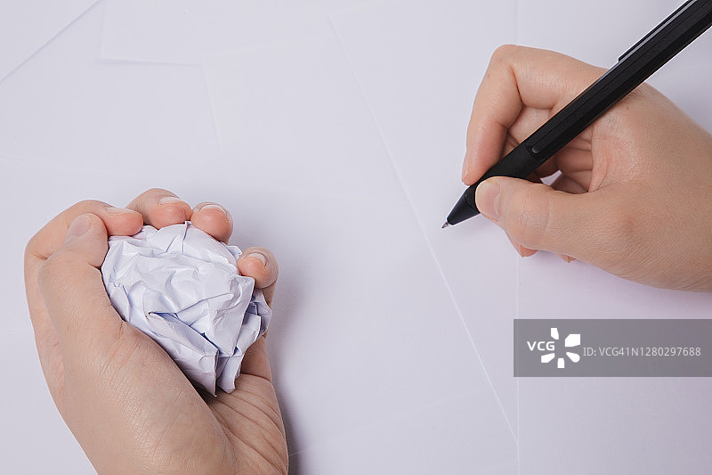 女人手持纸团和笔图片素材