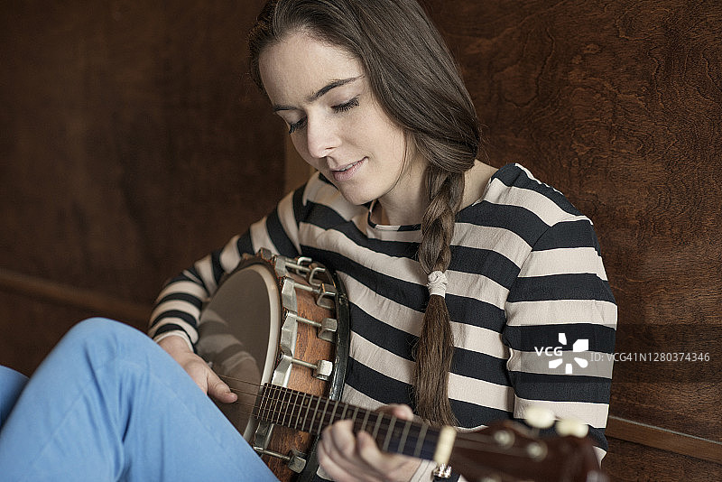 年轻女子弹奏班卓琴特写图片素材