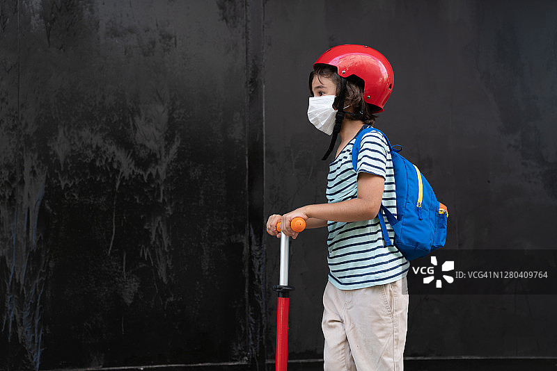 戴口罩骑滑板车上学的男学生图片素材