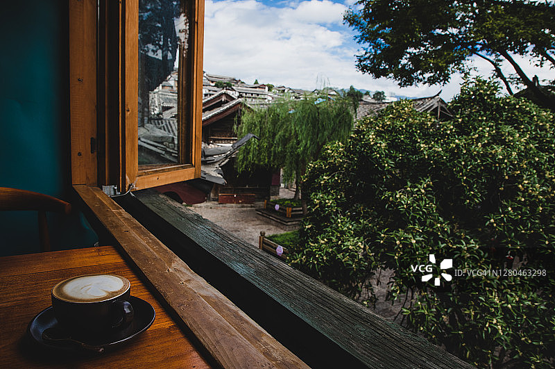 享受一杯热拿铁咖啡，窗外景色优美图片素材