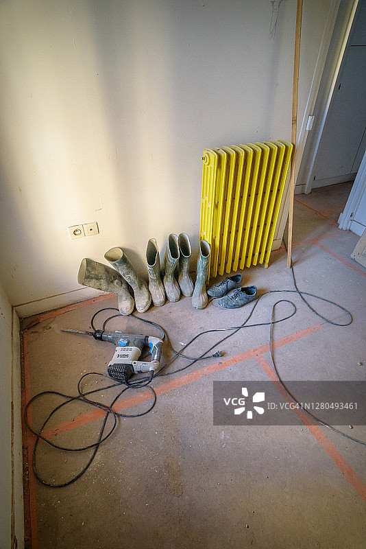 正在翻新的房子里的靴子、散热器和镗床图片素材