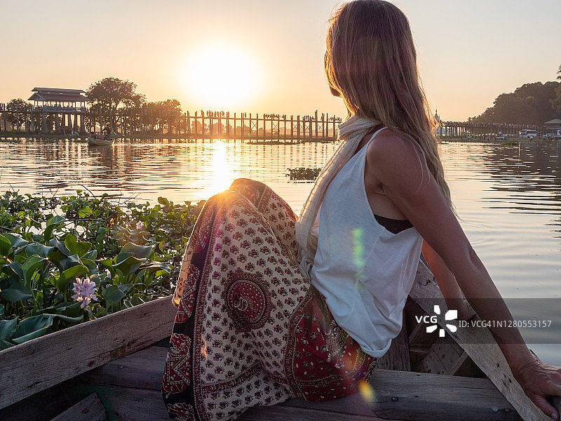 女人在长尾船上欣赏乌本桥日落图片素材