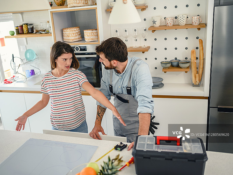 修理工人在厨房修理木制橱柜图片素材