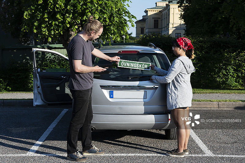 男女在车上放置学习盘图片素材