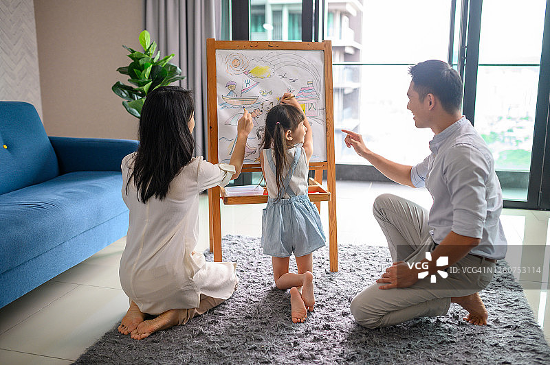 可爱的亚洲女孩用蜡笔给旅行素描上色图片素材