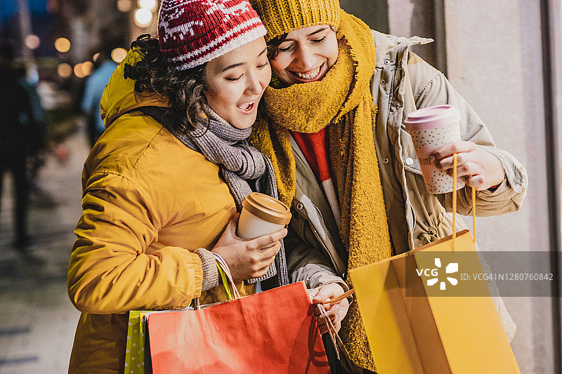 两个女人在假期购物季提着购物袋图片素材