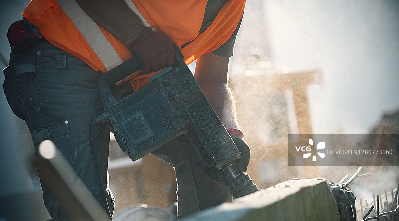 男人使用手提式破碎机在后院破碎混凝土块图片素材