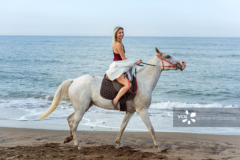 美丽女人在海滩骑马图片素材