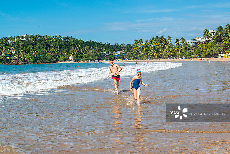 父亲在斯里兰卡马特勒米瑞沙海滩和女儿玩耍图片素材