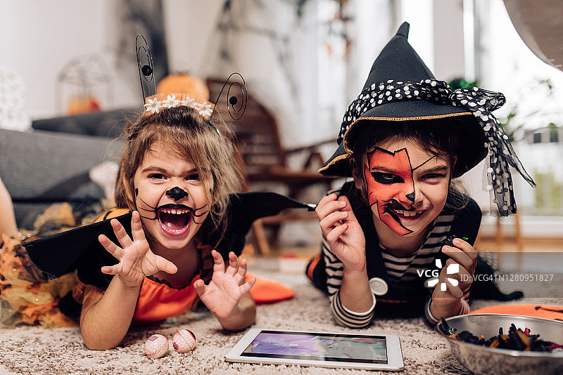 两个可爱的小姐妹在家里玩耍过万圣节的肖像图片素材