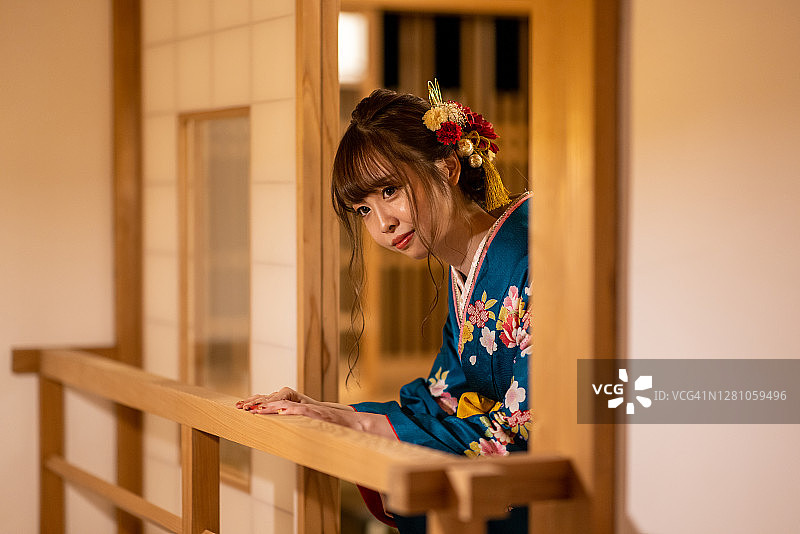 身穿“振袖”和服，在日式“榻榻米”房间里，从“日式旅馆”酒店欣赏风景的年轻女子图片素材