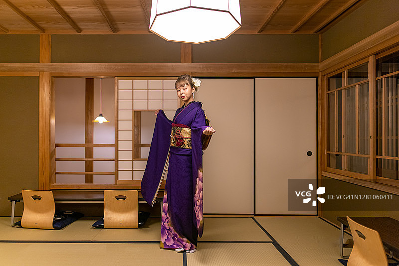 年轻女子身穿和服在日式榻榻米房间的日式旅馆酒店跳舞图片素材