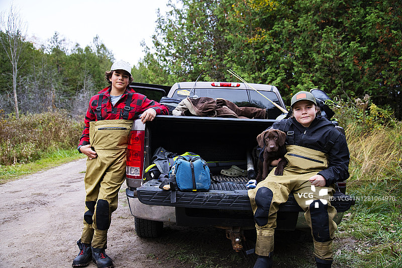 带着巧克力拉布拉多幼犬钓鱼图片素材