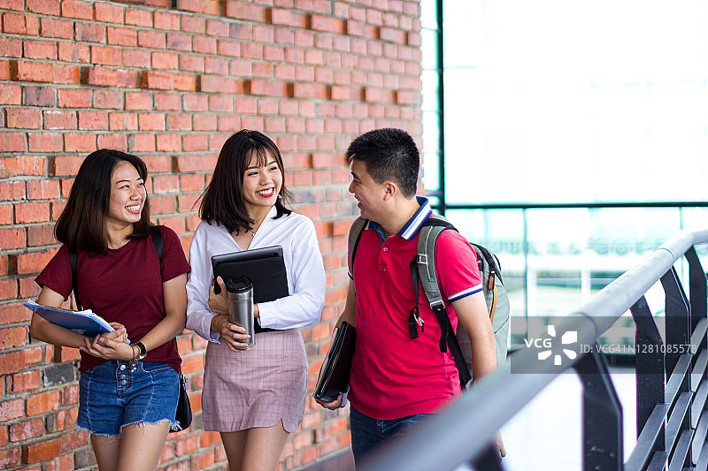 在校园里一起行走的成年学生图片素材