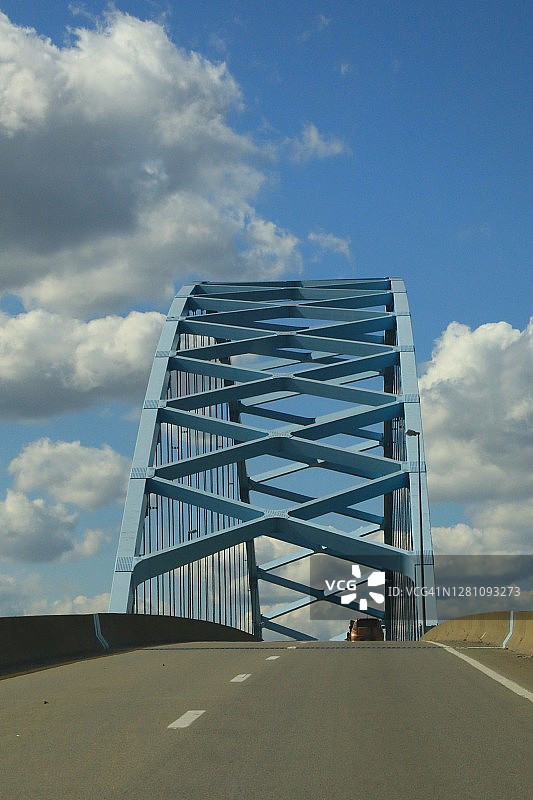 穿过单跨钢桁架桥的道路图片素材