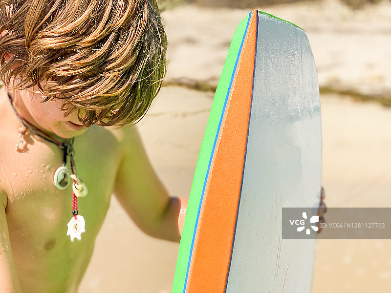 在加利福尼亚州圣巴巴拉海滩玩趴板的男孩图片素材