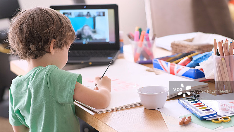 小男孩通过远程学习跟随学前班课程图片素材