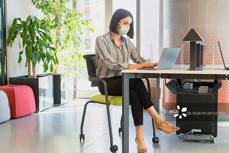 戴着防护口罩和手套在银行工作的女人图片素材