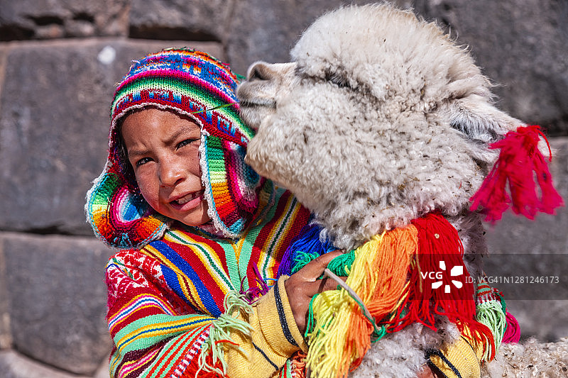 在库斯科附近与羊驼玩耍的秘鲁小男孩图片素材