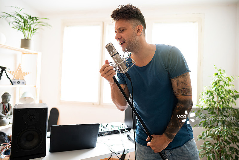 歌手在家用音乐工作室对着麦克风演唱新歌图片素材