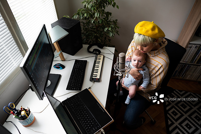 女音乐制作人在音乐工作室抱着她的男婴图片素材