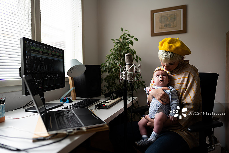 女音乐制作人在音乐工作室抱着她的男婴图片素材