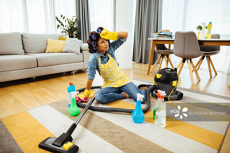 疲惫的中年妇女用很多工具打扫房子图片素材