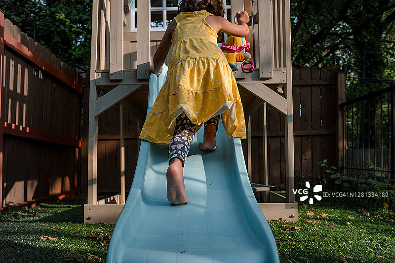 在后院爬滑梯的小女孩图片素材