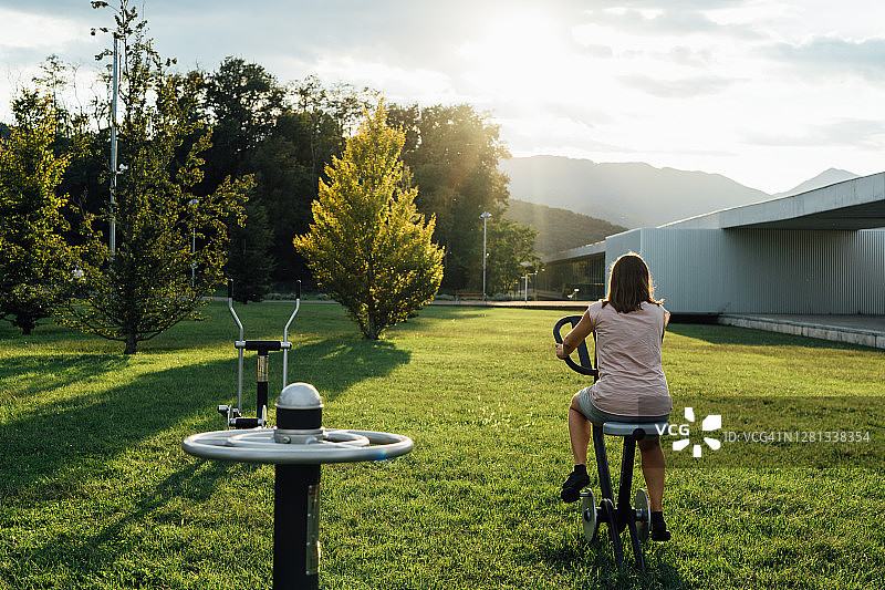 在公园用器械锻炼的女孩图片素材